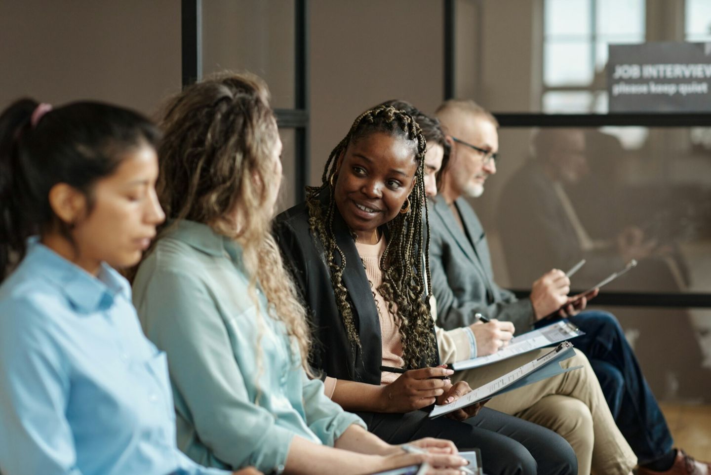 A group of people sitting in a row for interview, identified for ATS system.