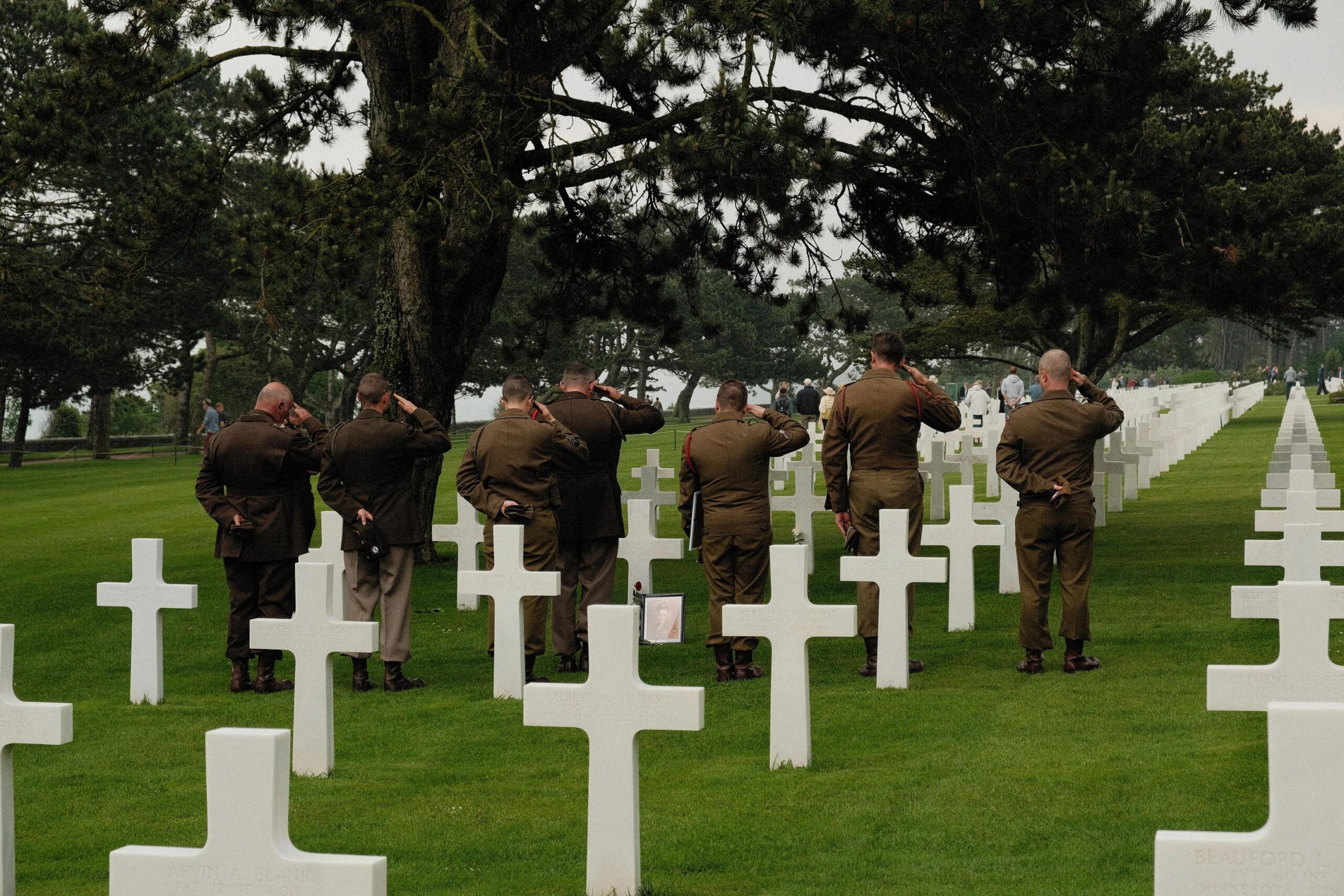 Service men saluting in Normandy War Cemetery respecting D-DAy