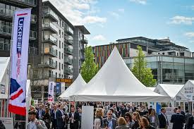 Open space, full of attendee's at UKREiiF in Leeds with gazebo's in foreground.